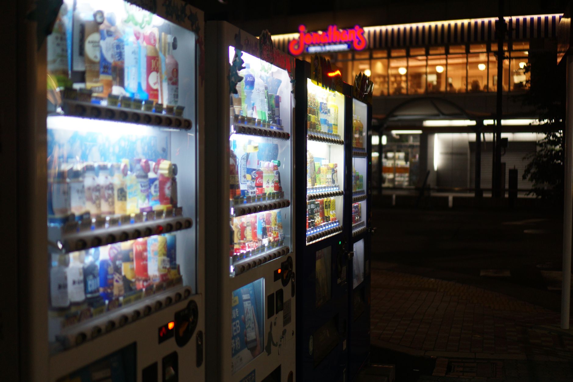 Distributeurs automatiques illuminés dans une rue de Tokyo