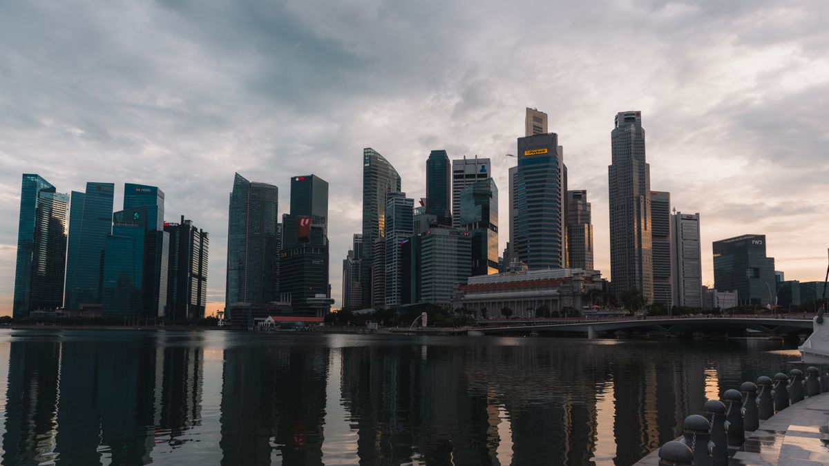 Skyline de Singapour illuminée au crépuscule avec reflets sur l'eau