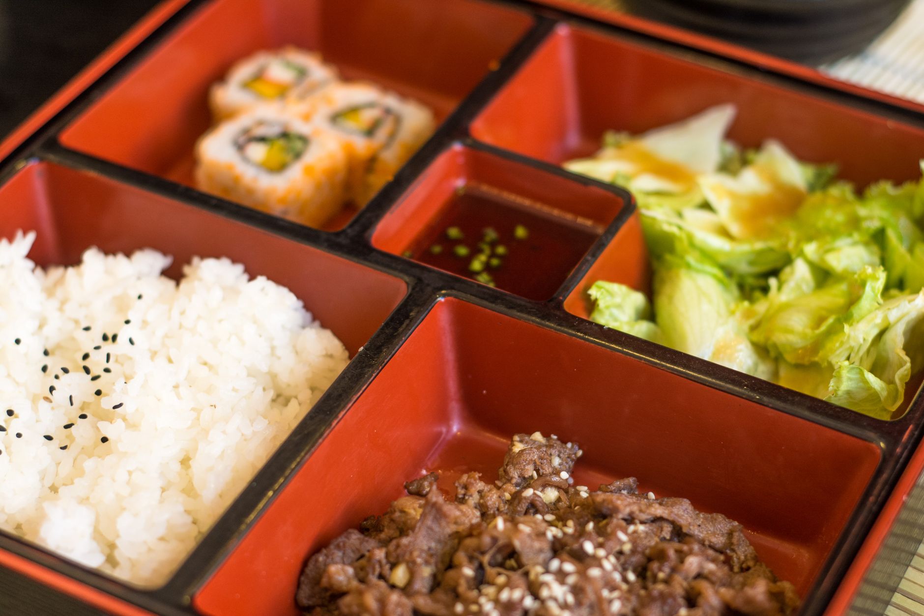 Bento japonais compartimenté avec riz, sushi et accompagnements