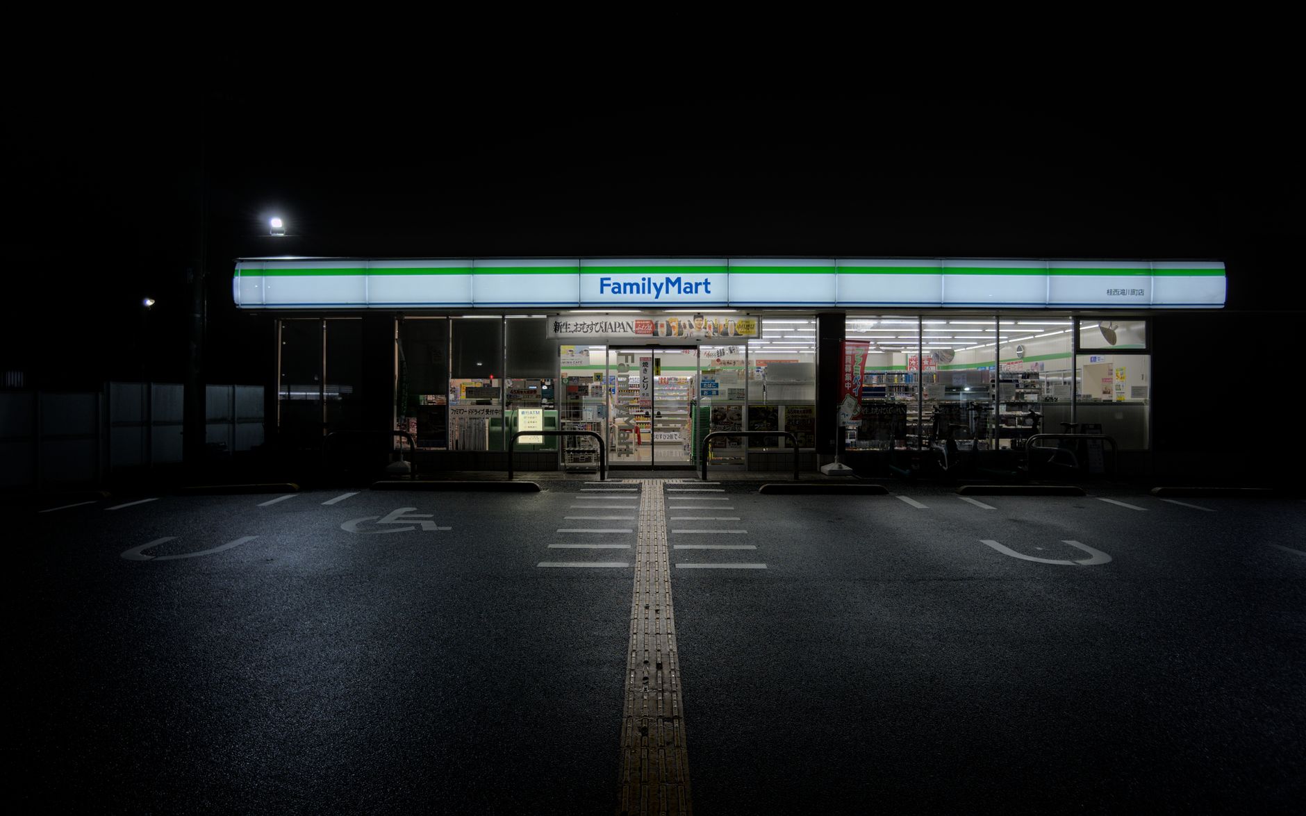 Devanture éclairée d'un konbini FamilyMart dans une rue japonaise, de nuit
